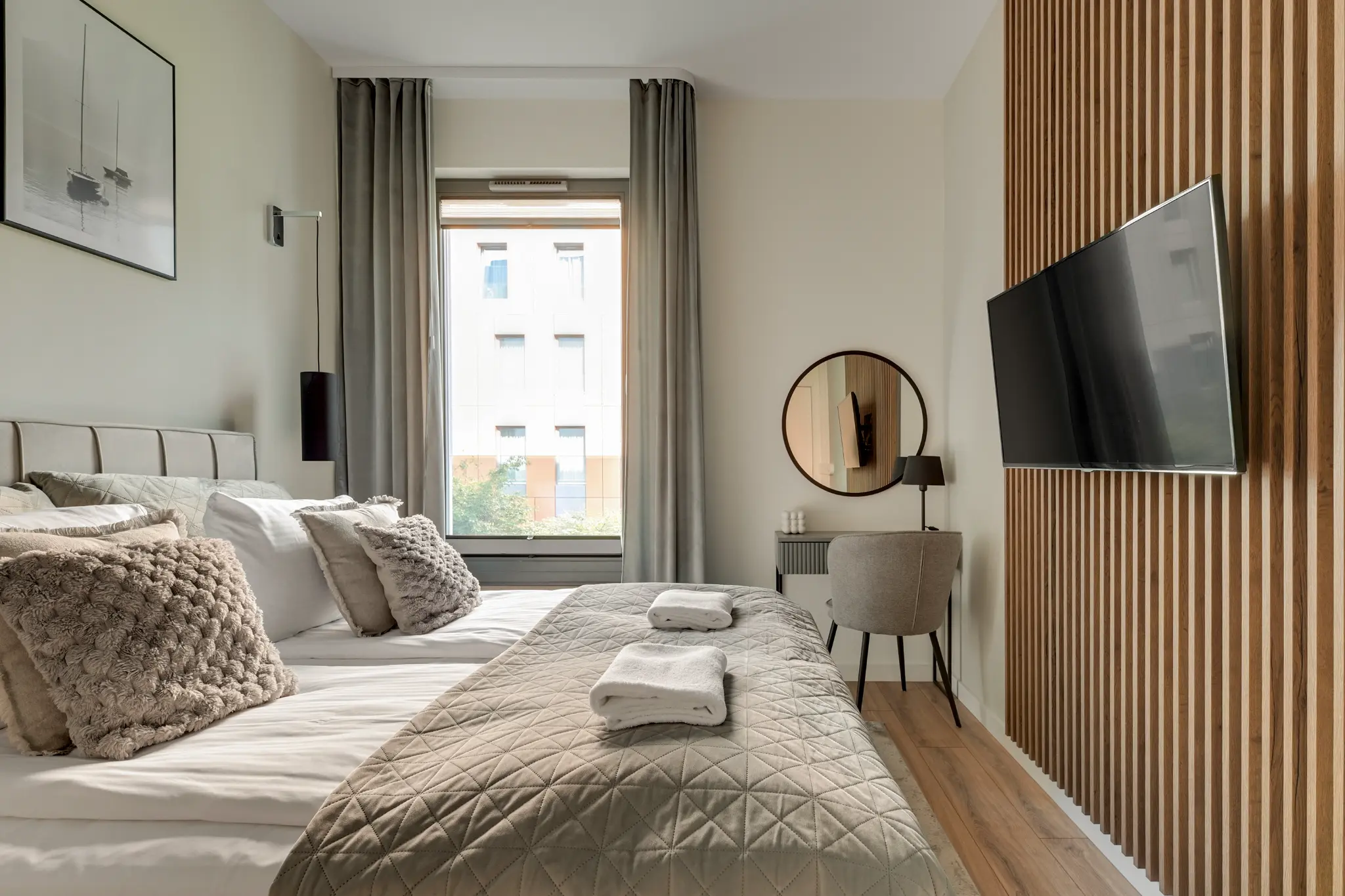 Sypialnia apartamentu Brabank z podwójnym łóżkiem, drewnianymi lamelami i toaletką
