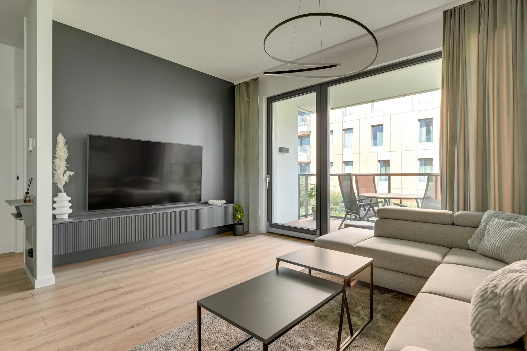 Salon apartamentu Brabank z sofą, telewizorem i wyjściem na umeblowany balkon