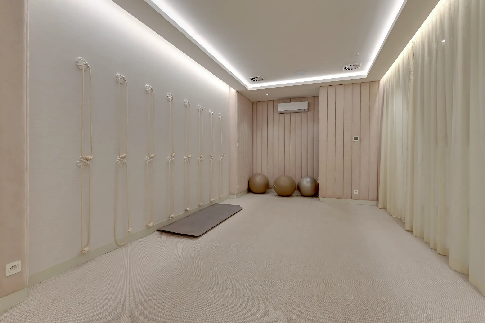 Sala do ćwiczeń w Brabanku z matą, piłkami i linami zamocowanymi do ściany
