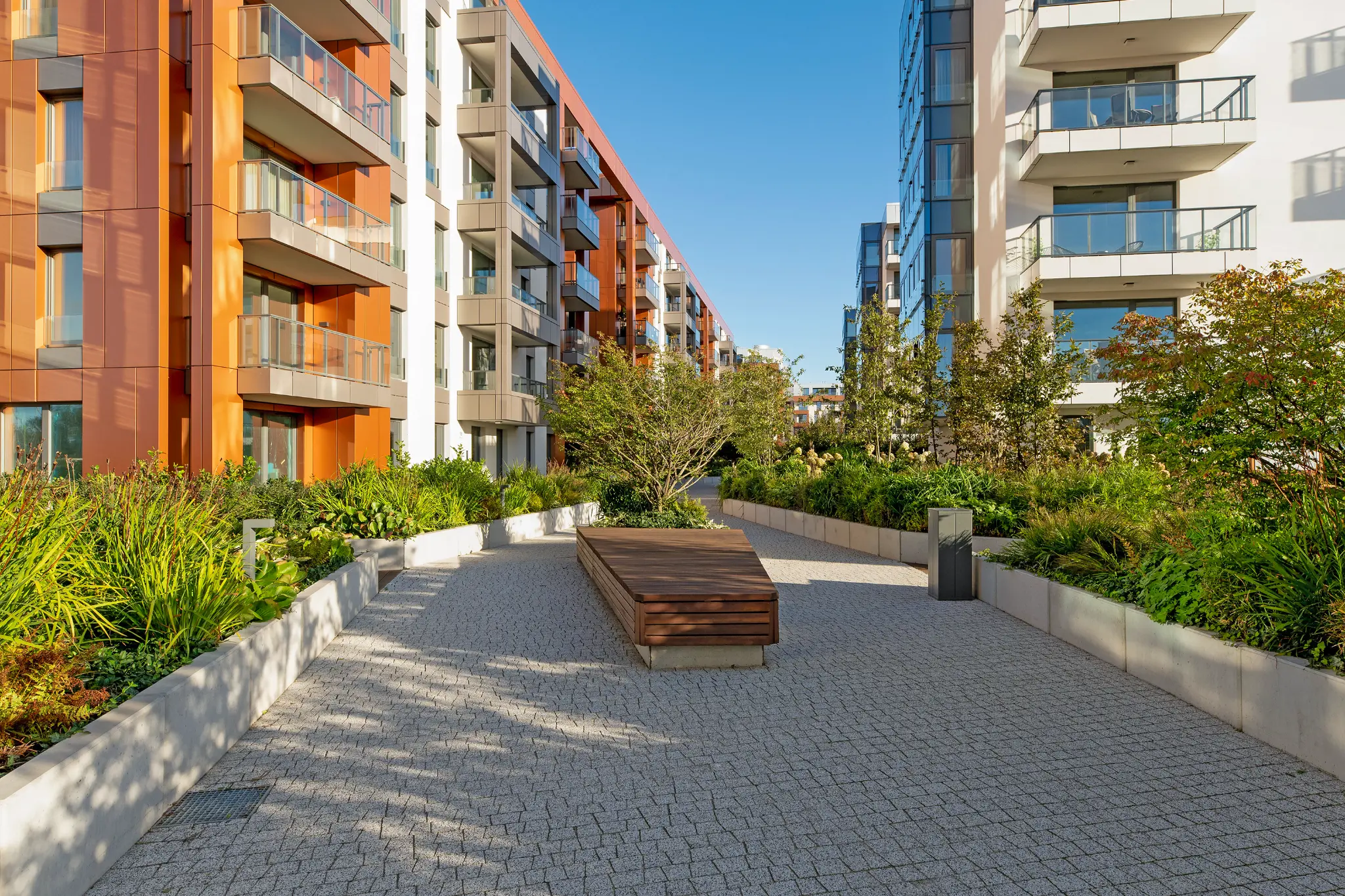 Zielony dziedziniec Brabanku pomiędzy budynkami z miedzianymi i szarymi elewacjami