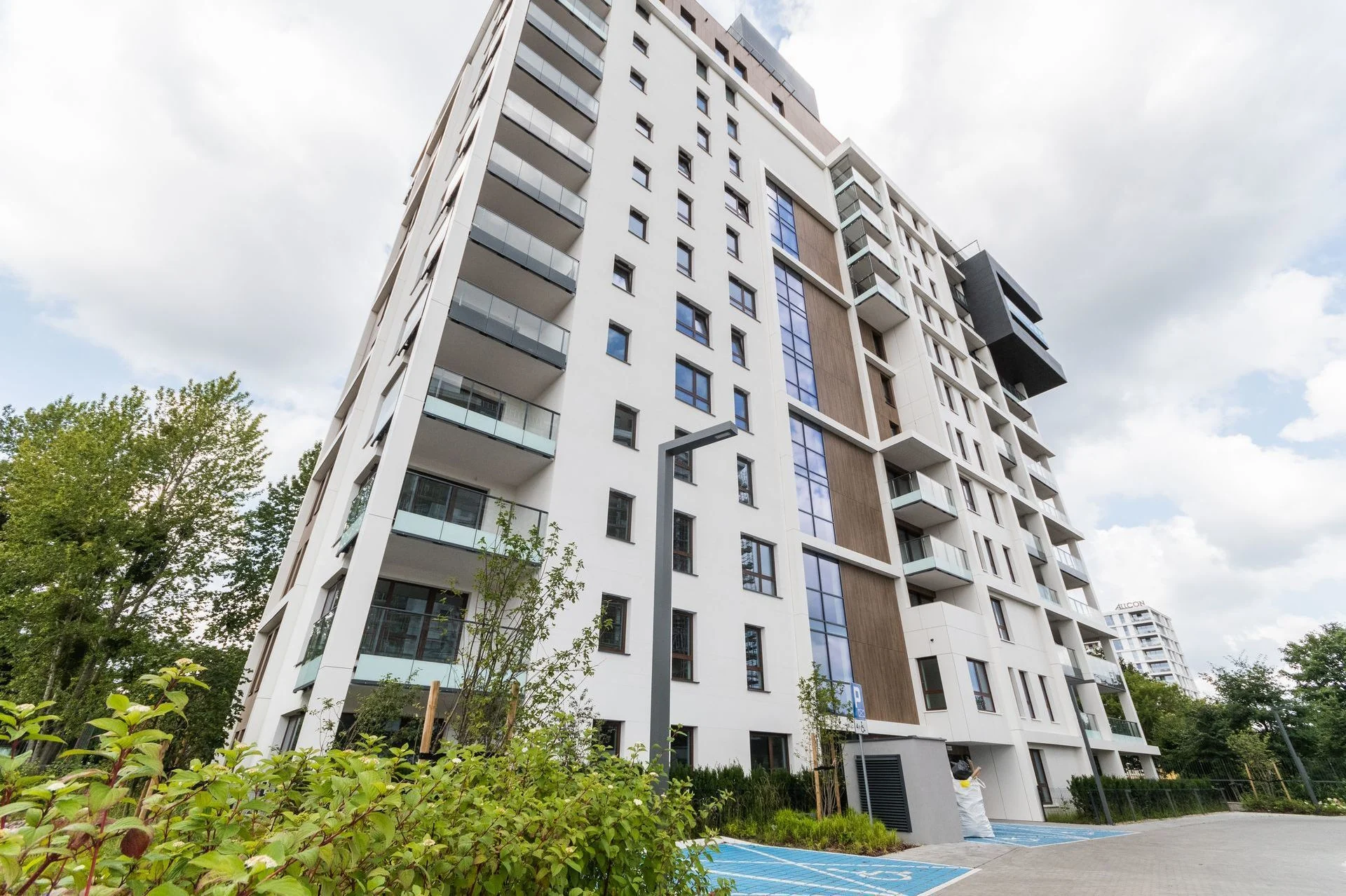 Front of the Bulvar Apartments building in Gdansk — light façade, balconies and greenery by the entrance