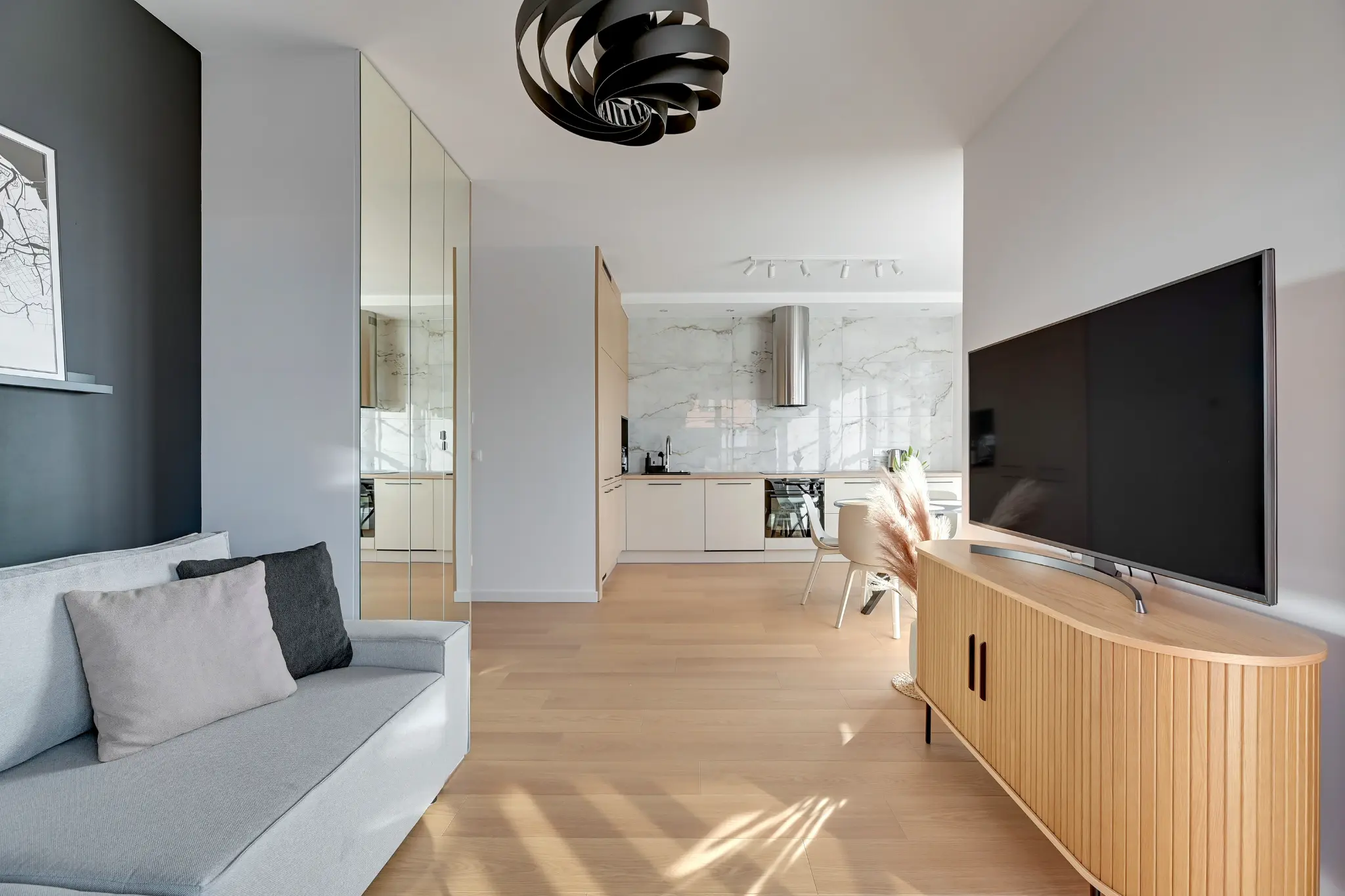 Salon i aneks kuchenny w apartamencie DOKI obsługiwanym przez GrandRent