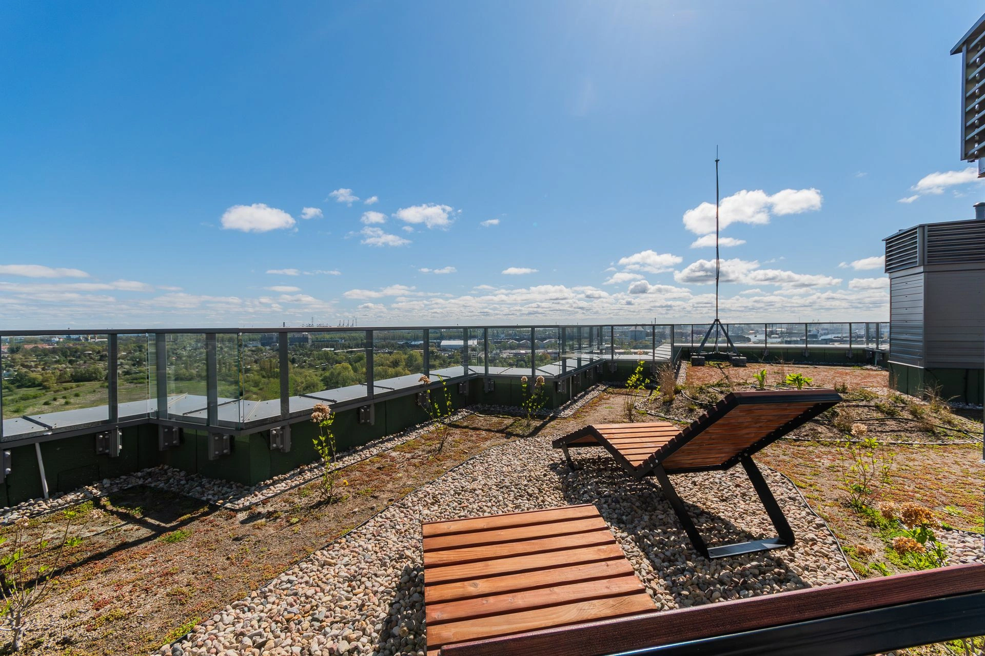 Drewniane leżaki na tarasie Horizona z panoramą Gdańska