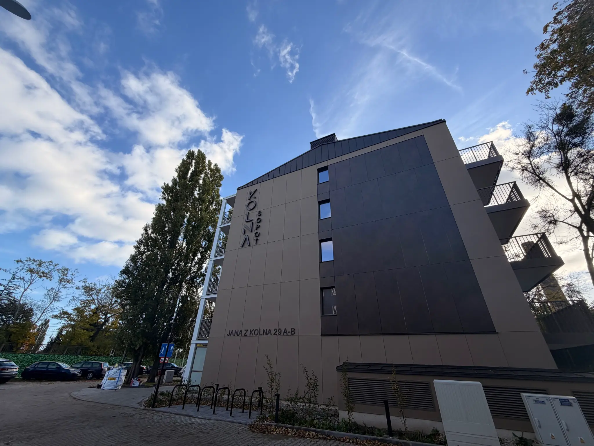 Kolna Sopot — façade with the development name and Jana z Kolna 29A–B address, trees by the building