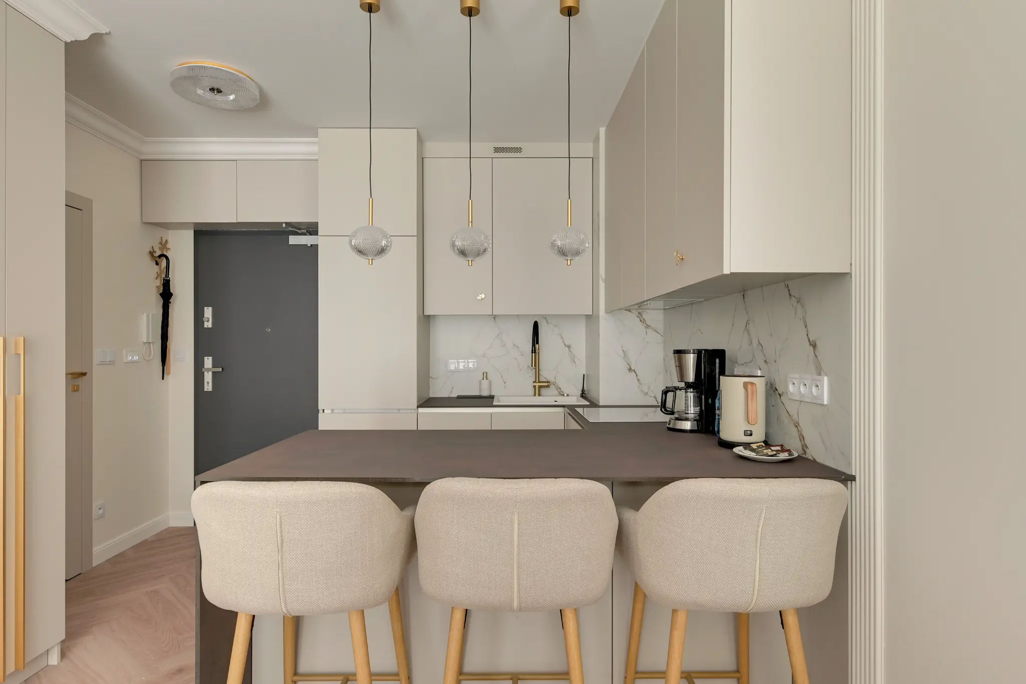 Kitchen with a wide worktop and three chairs in an apartment in Portovo