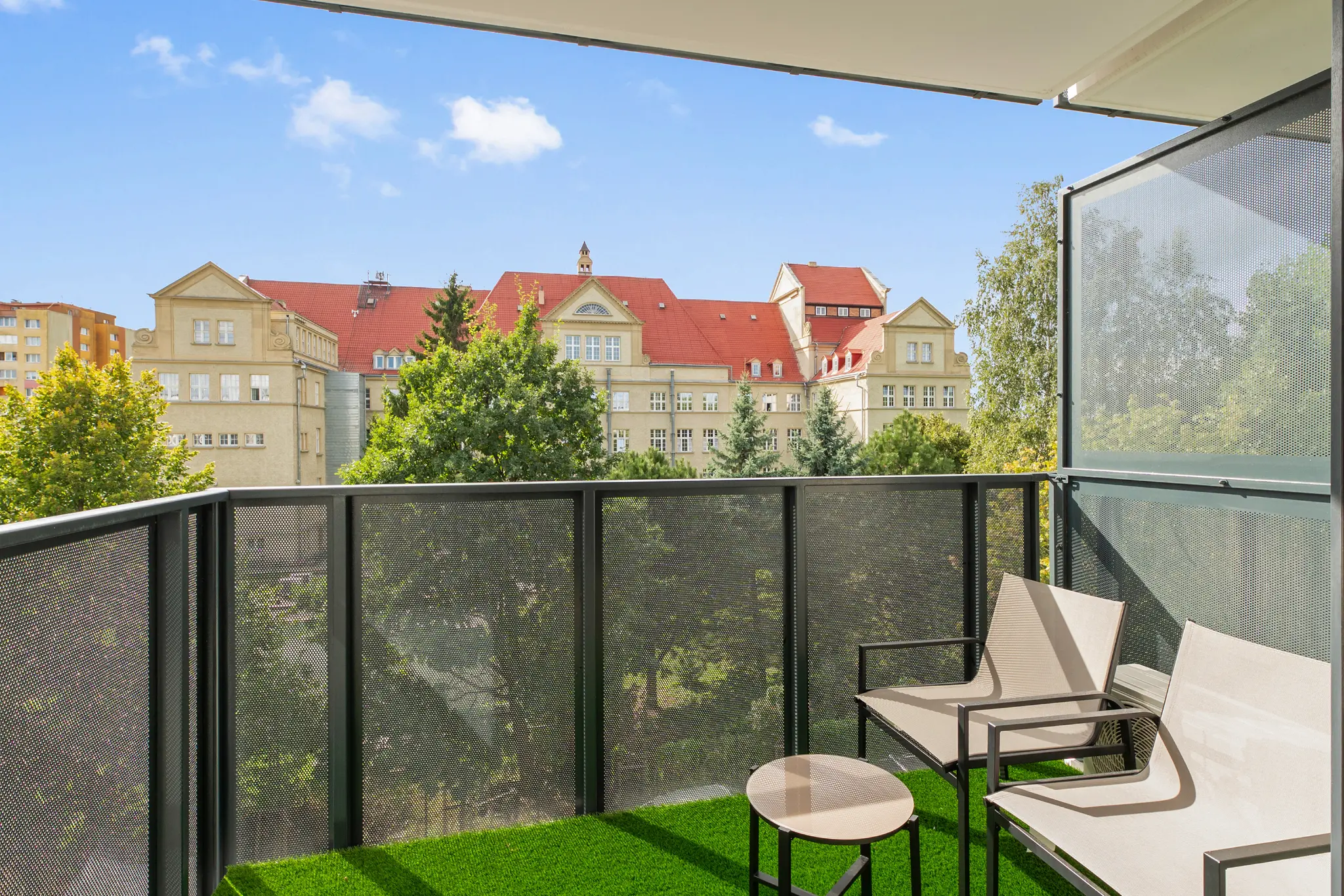 Balcony with a table and chairs and a view of the buildings at Mostek