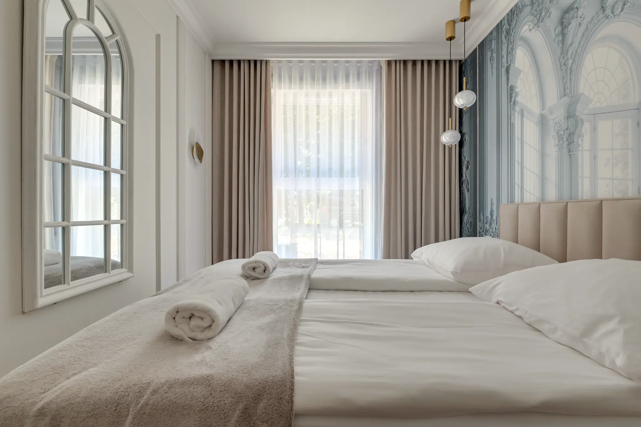 Bedroom with a light-coloured bed and decorative wall in an apartment in Murapol Portovo