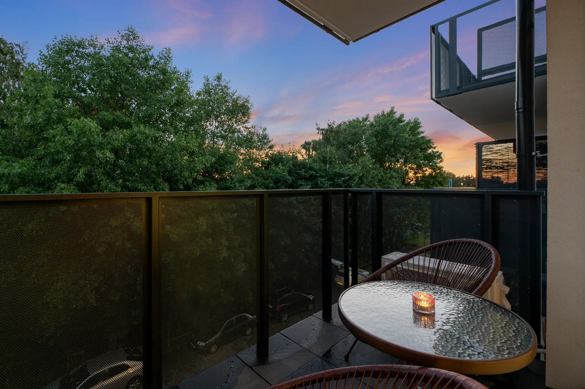 Balcony of an apartment at Mostek with a table, chairs and a view at dusk