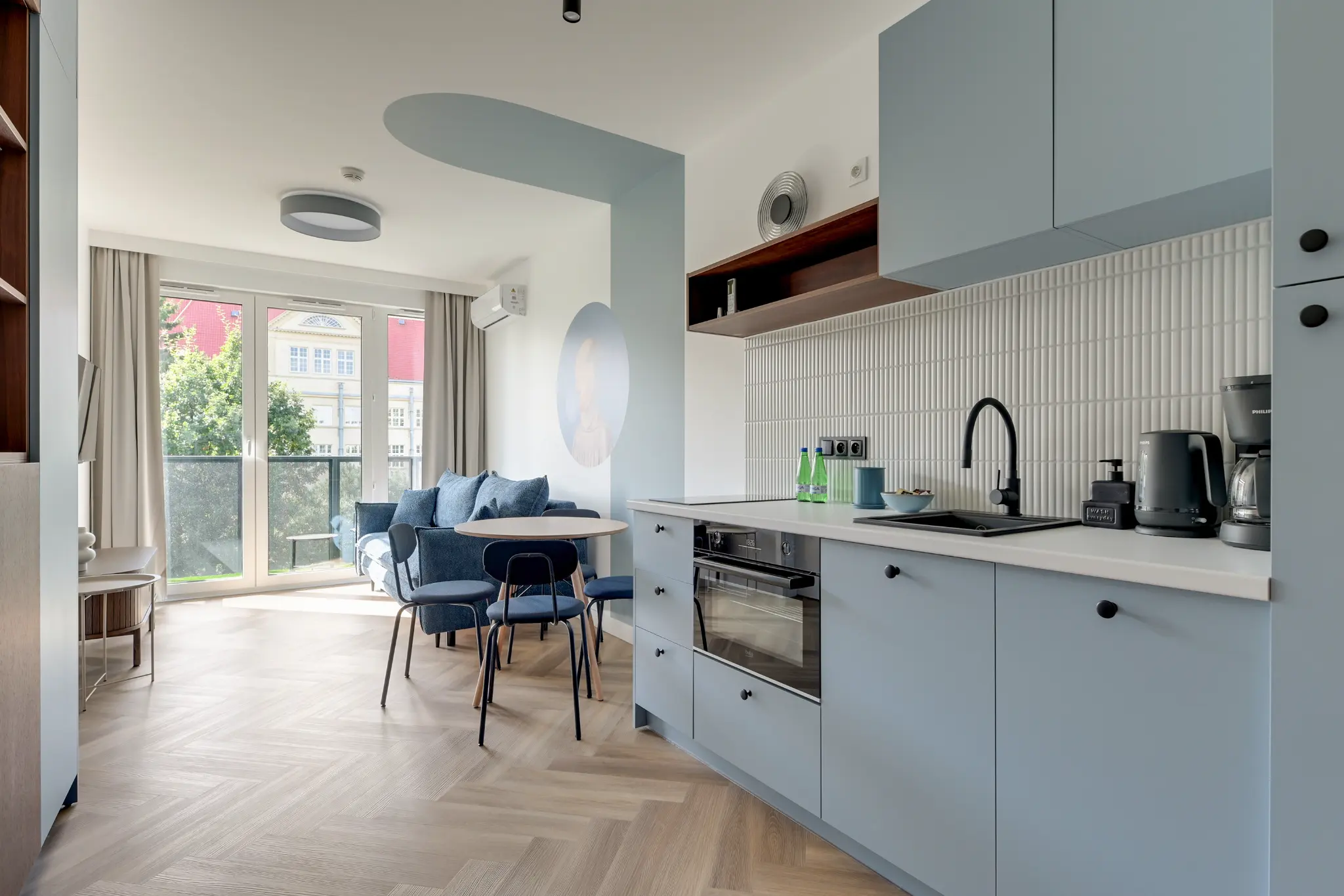 Blue kitchenette and living area with access to a balcony in Portovo