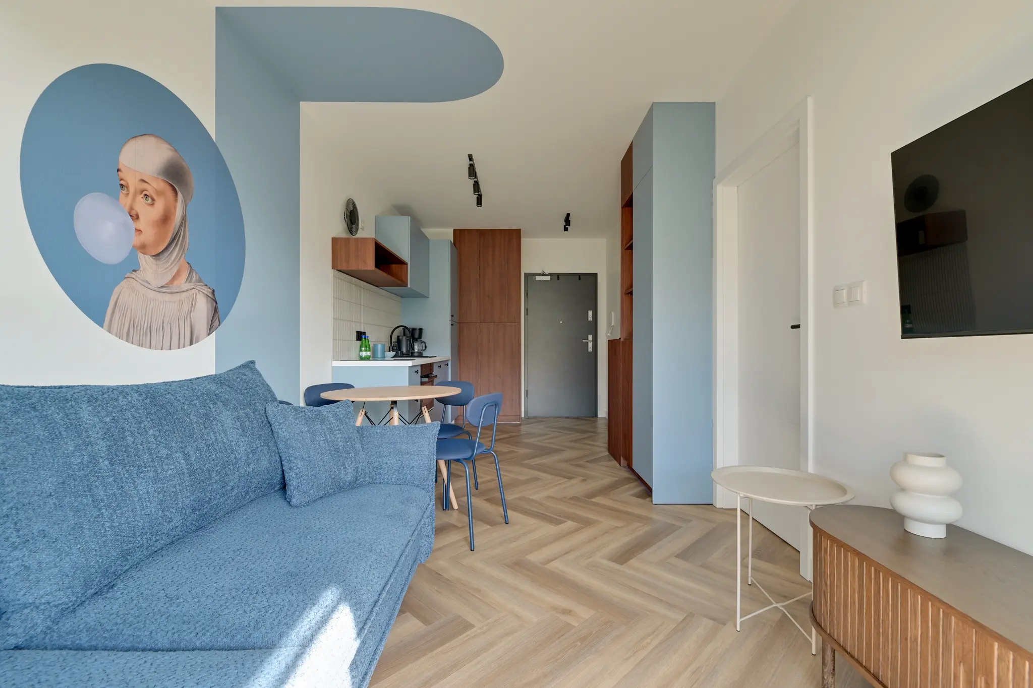 Blue sofa, dining area and wall decor in an apartment at Mostek