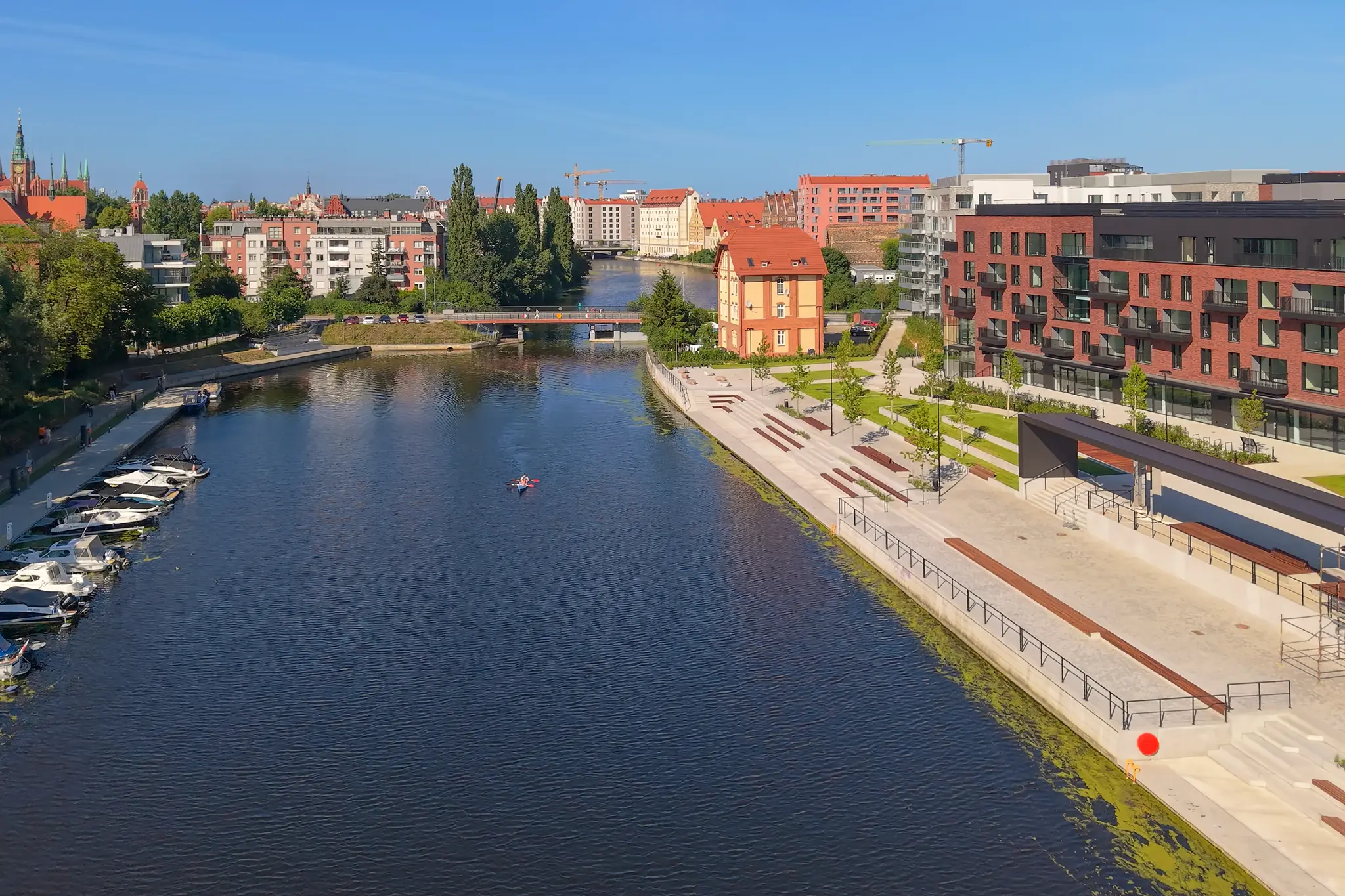 Szeroki widok Starej Motławy z łodziami, bulwarem OFF Miasto i panoramą Gdańska