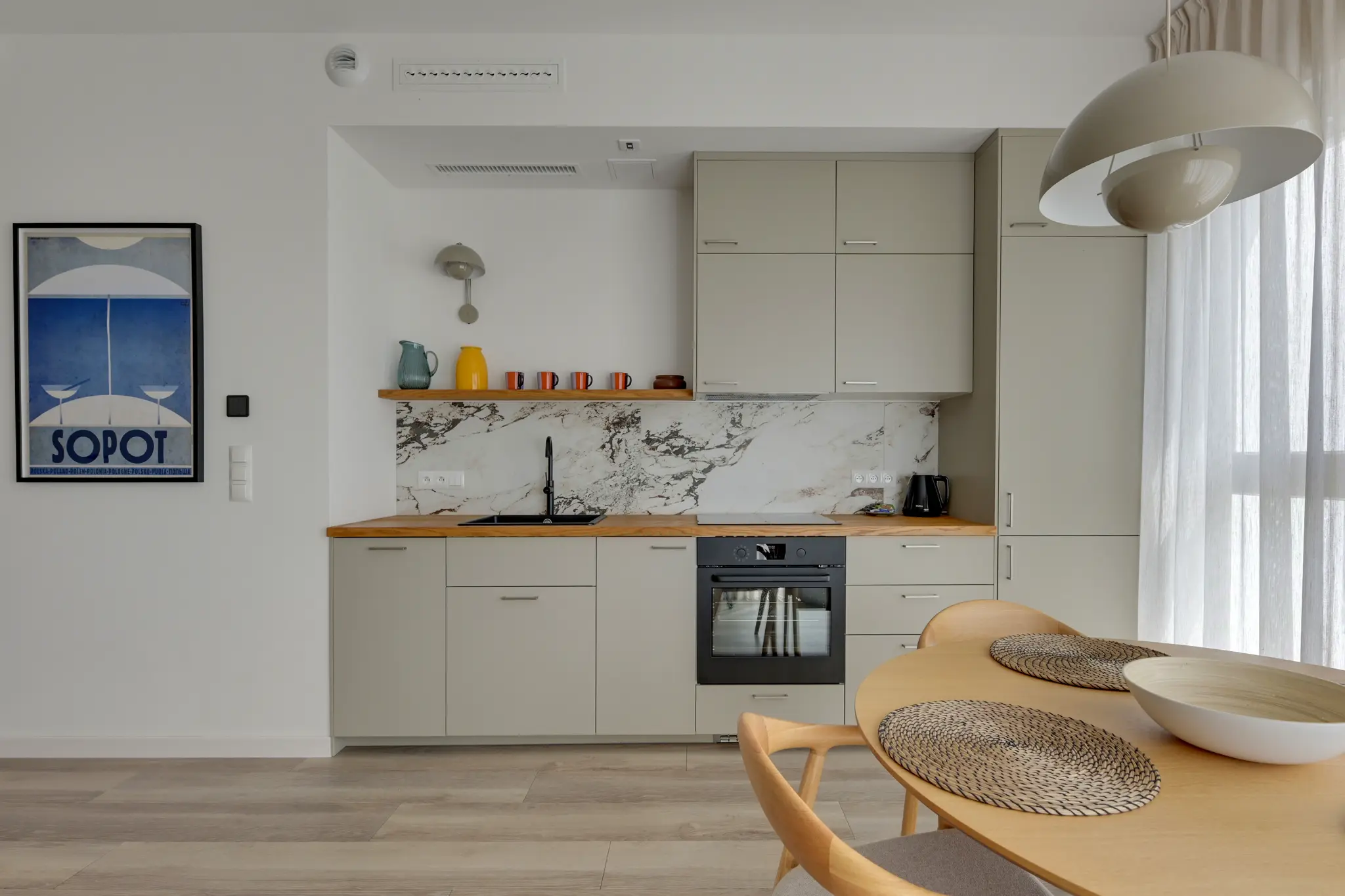 Jasny aneks kuchenny z drewnianym blatem w apartamencie Sol Marina
