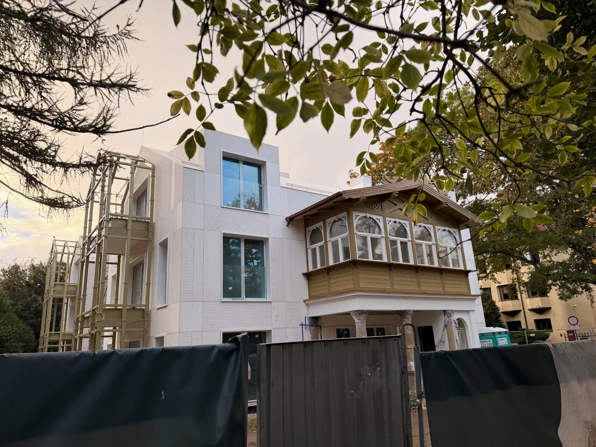 Villa Norden in Sopot — light façade and ornate wooden veranda behind the construction fence