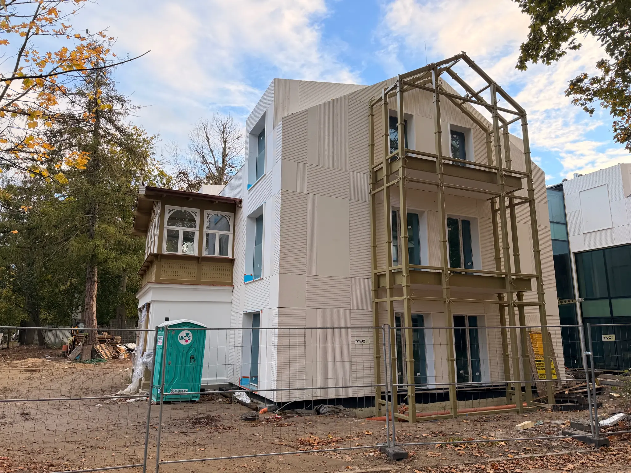 Side view of Villa Norden — light building, scaffolding by the façade and wooden veranda