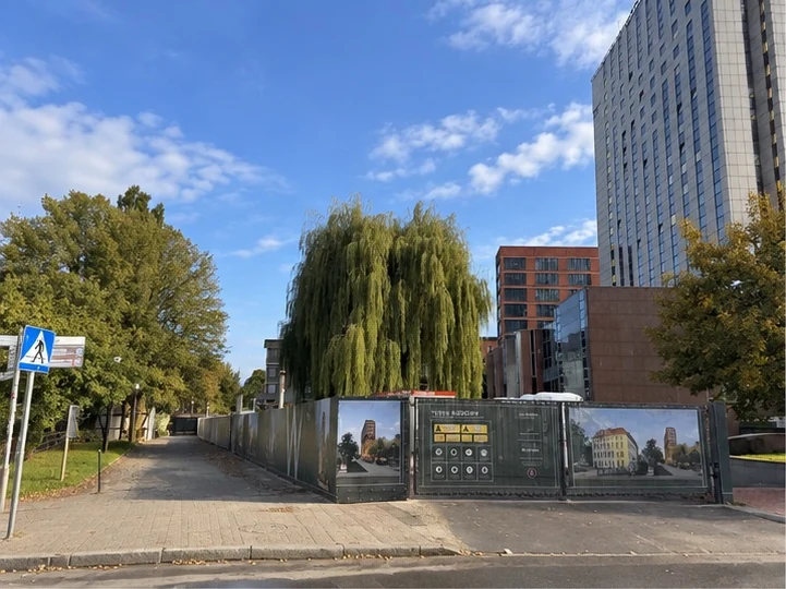 Projektgelände Wodopój Moderna in Gdańsk — Zaun, Bäume und bestehende Bebauung in der Umgebung