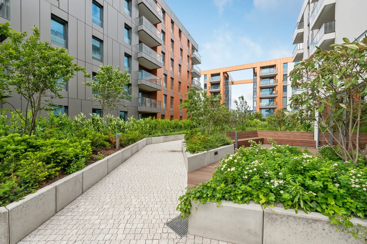 Green courtyard and buildings of the Brabank development in Gdańsk.
